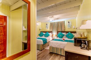 Cozy retreat with two single beds, a kitchenette, and a ceiling fan.