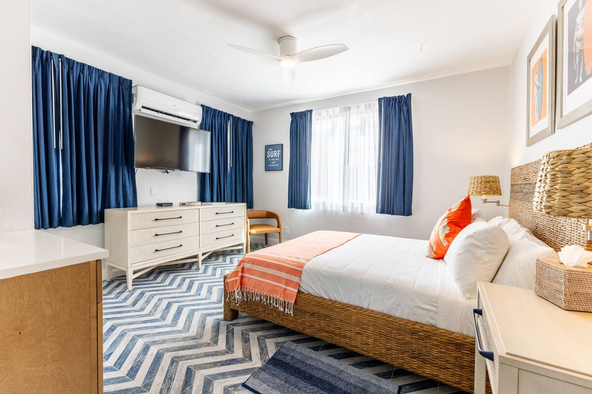 Quarto com cama, penteadeira e ventilador de teto.