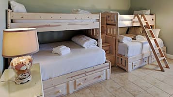 Cozy bedroom with a single bed and bunk bed setup, featuring a nightstand and lamp.