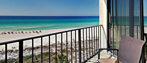 A balcony with a view of a beach and ocean.