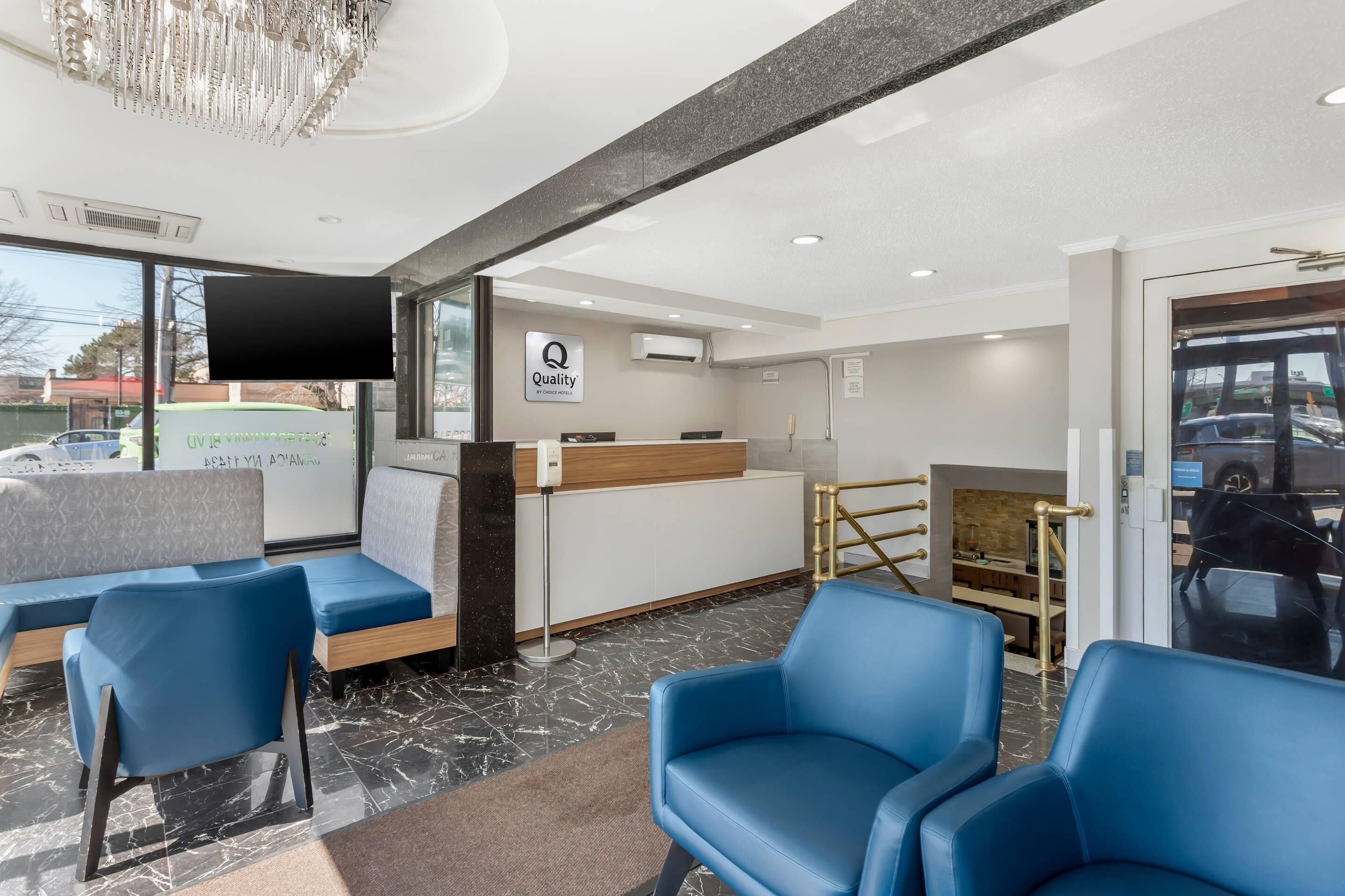 A reception area with a counter, seating, and a chandelier.