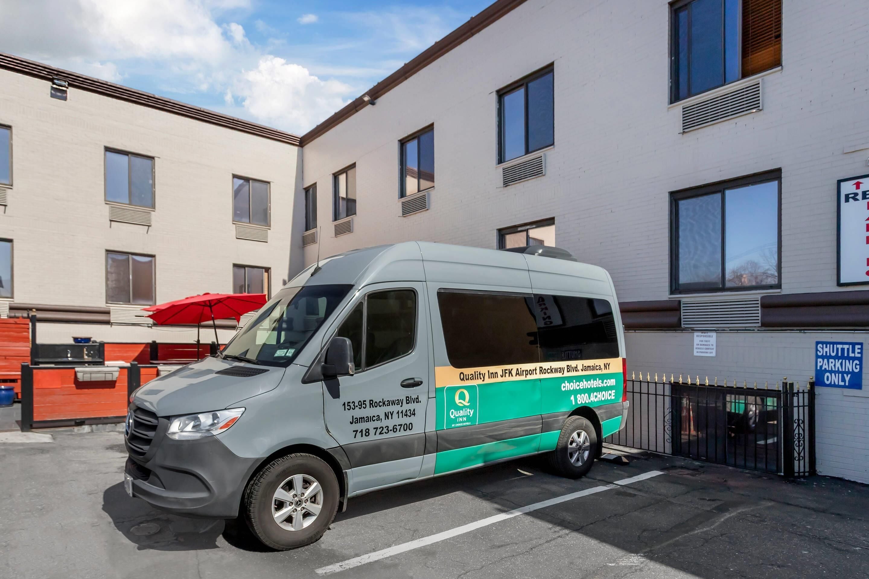 Una camioneta estacionada frente a un edificio con un letrero que indica estacionamiento de transporte.