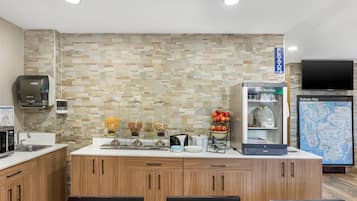 A modern kitchen with a stone backsplash, a refrigerator, a coffee machine, and a Subway map on the wall.