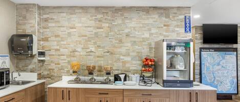 A modern kitchen with a stone backsplash, a refrigerator, a coffee machine, and a Subway map on the wall.