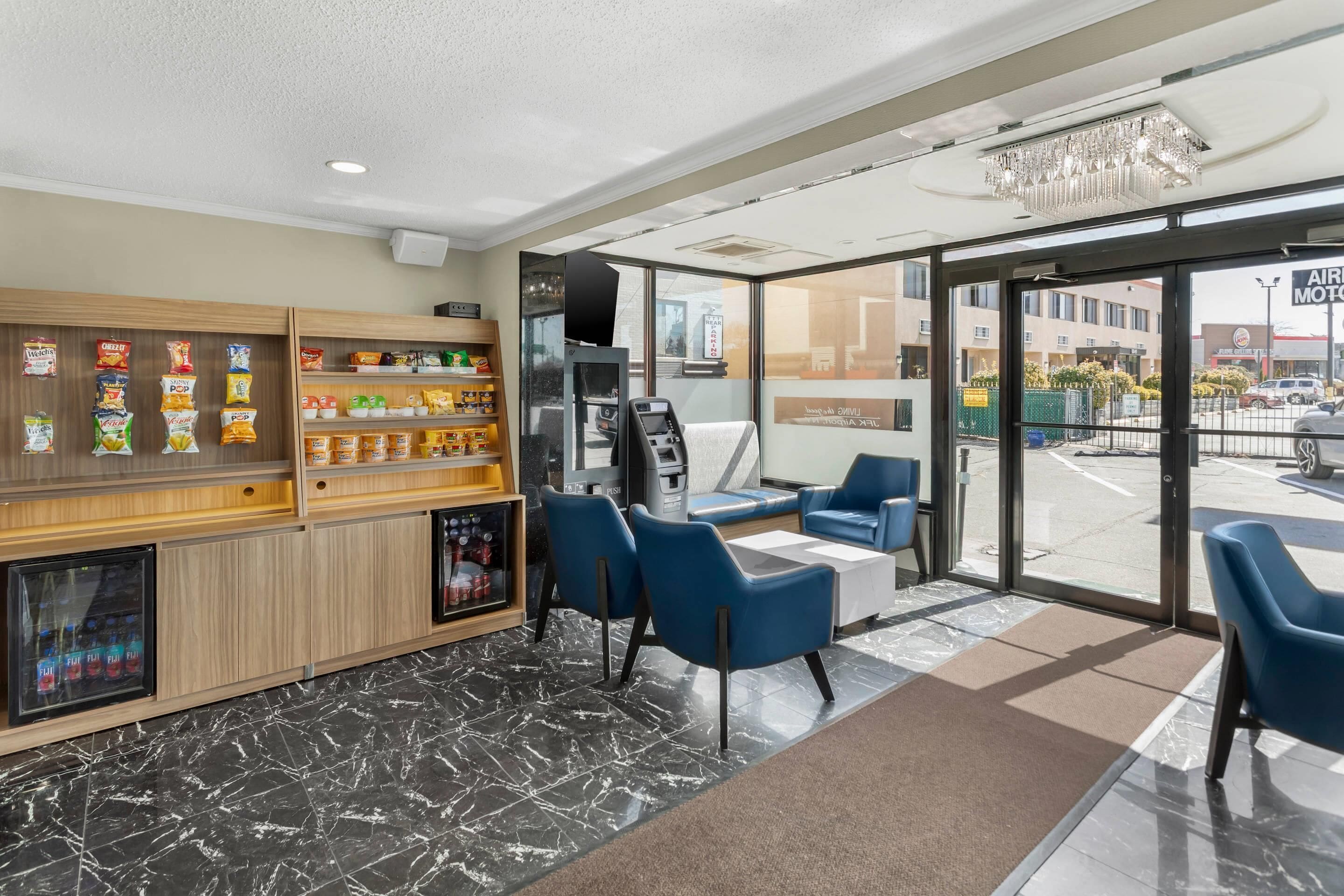 A modern lobby with seating, vending machines, and a view of the street.
