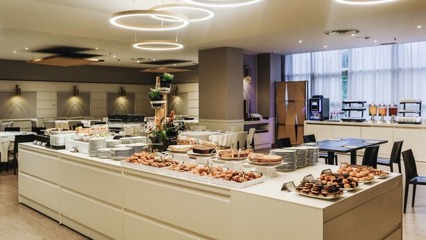Un espace repas moderne, aménagé avec un buffet proposant une variété de plats et un coin café.