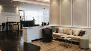 Un salon moderne comprenant un canapé, une table basse et un coin repas avec des chaises et une table.