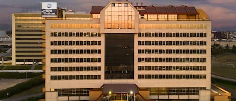 Un hotel grande con un llamativo letrero de Best Western, varios pisos y una entrada central con área cubierta.