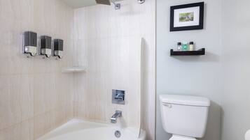 A modern bathroom with a bathtub, toilet, and shower.