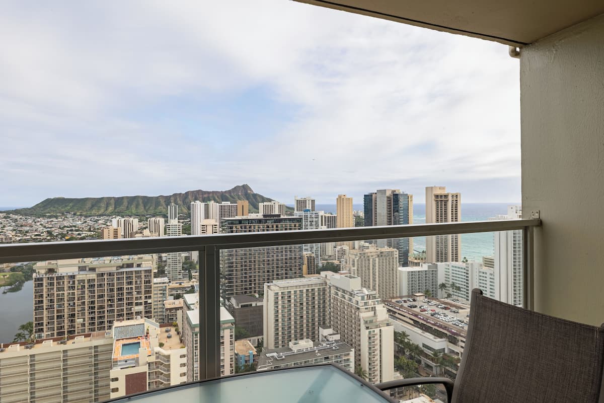 A high-rise hotel room with a view of a cityscape and a mountain.