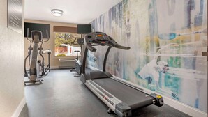 A fitness center with treadmills, stationary bikes, and a large abstract mural on the wall. - Best Western Gardendale (Gardendale)