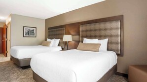 A hotel room with two beds, a large headboard, a framed picture on the wall, and a carpeted floor. - Best Western Gardendale (Gardendale)