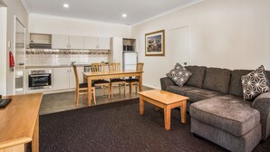 Un espacio habitable compacto con kitchenette, comedor y sofá.