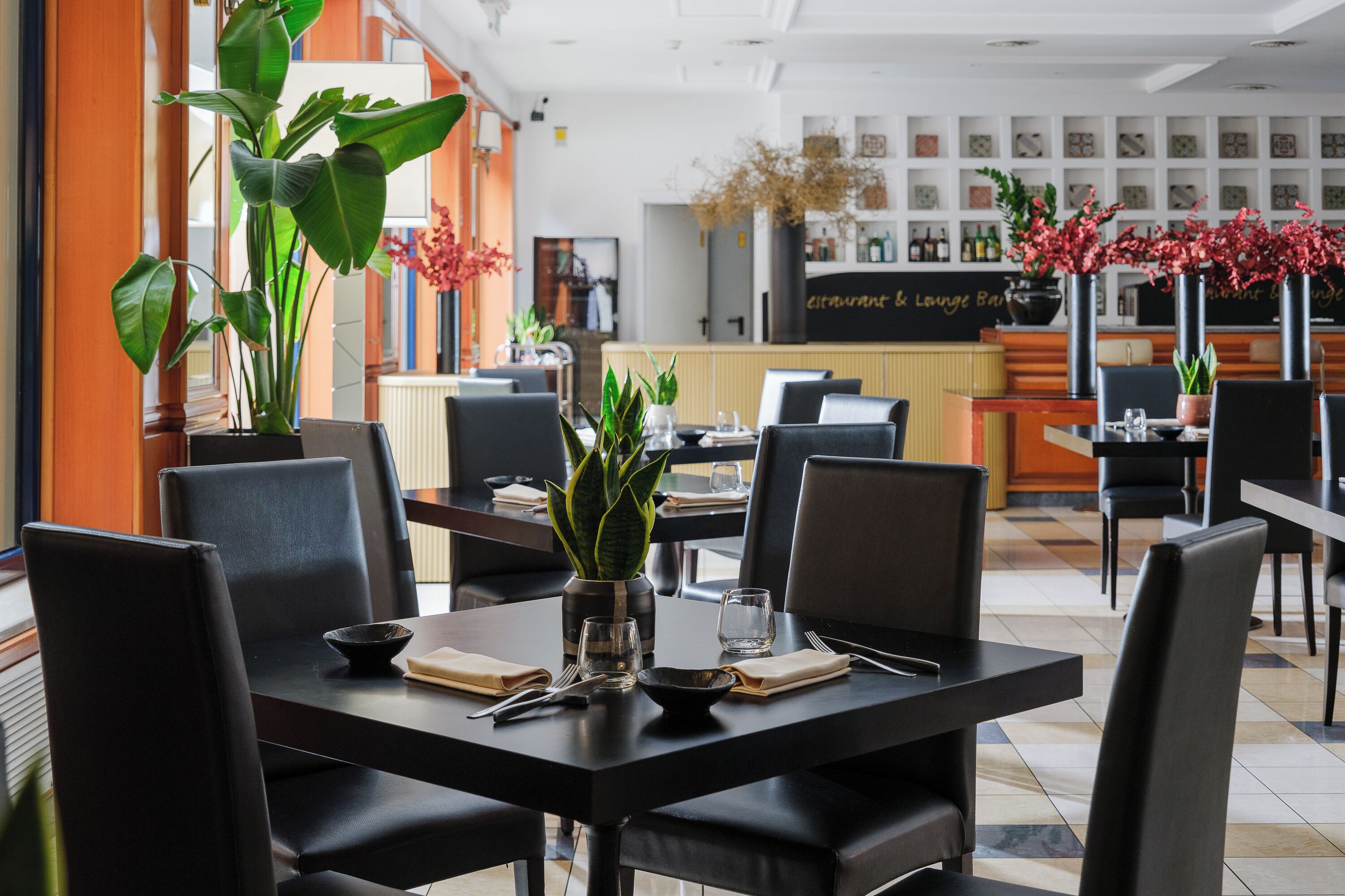 A restaurant interior with tables, chairs, and a bar area.