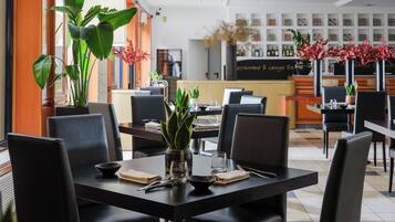 A restaurant interior with tables, chairs, and a bar area.