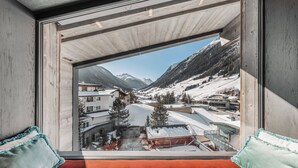 Una habitación con un ventanal que ofrece vistas a un paisaje montañoso nevado.