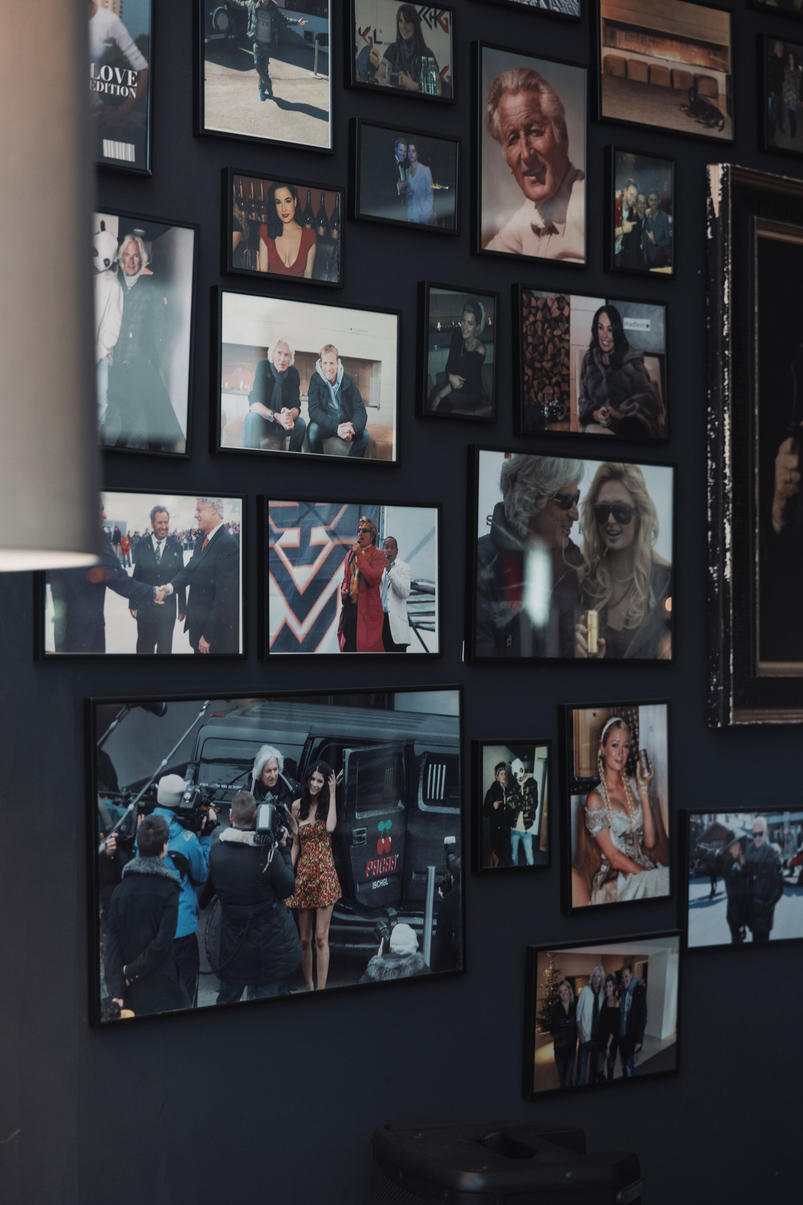 A wall with multiple framed photographs.