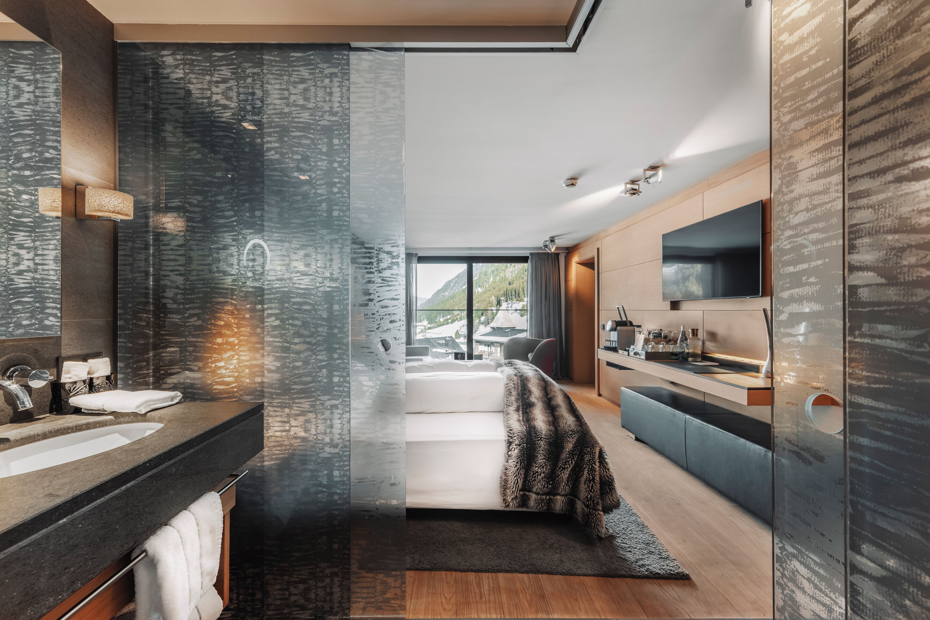 A modern bathroom with a large mirror, a sink, and a shower area.