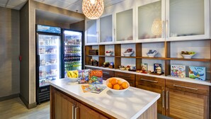 A modern kitchen with a central island, built-in appliances, and wooden cabinetry. - Homewood Suites by Hilton Oakland-Waterfront (Oakland)