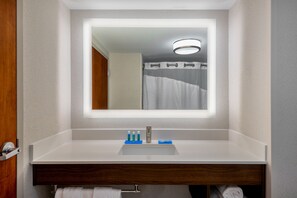 A bathroom with a white sink, a mirror, and a towel rack. - Holiday Inn Express Chapel Hill by IHG (Chapel Hill)