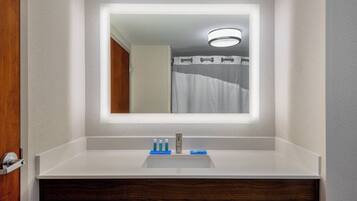 A bathroom with a white sink, a mirror, and a shower curtain.