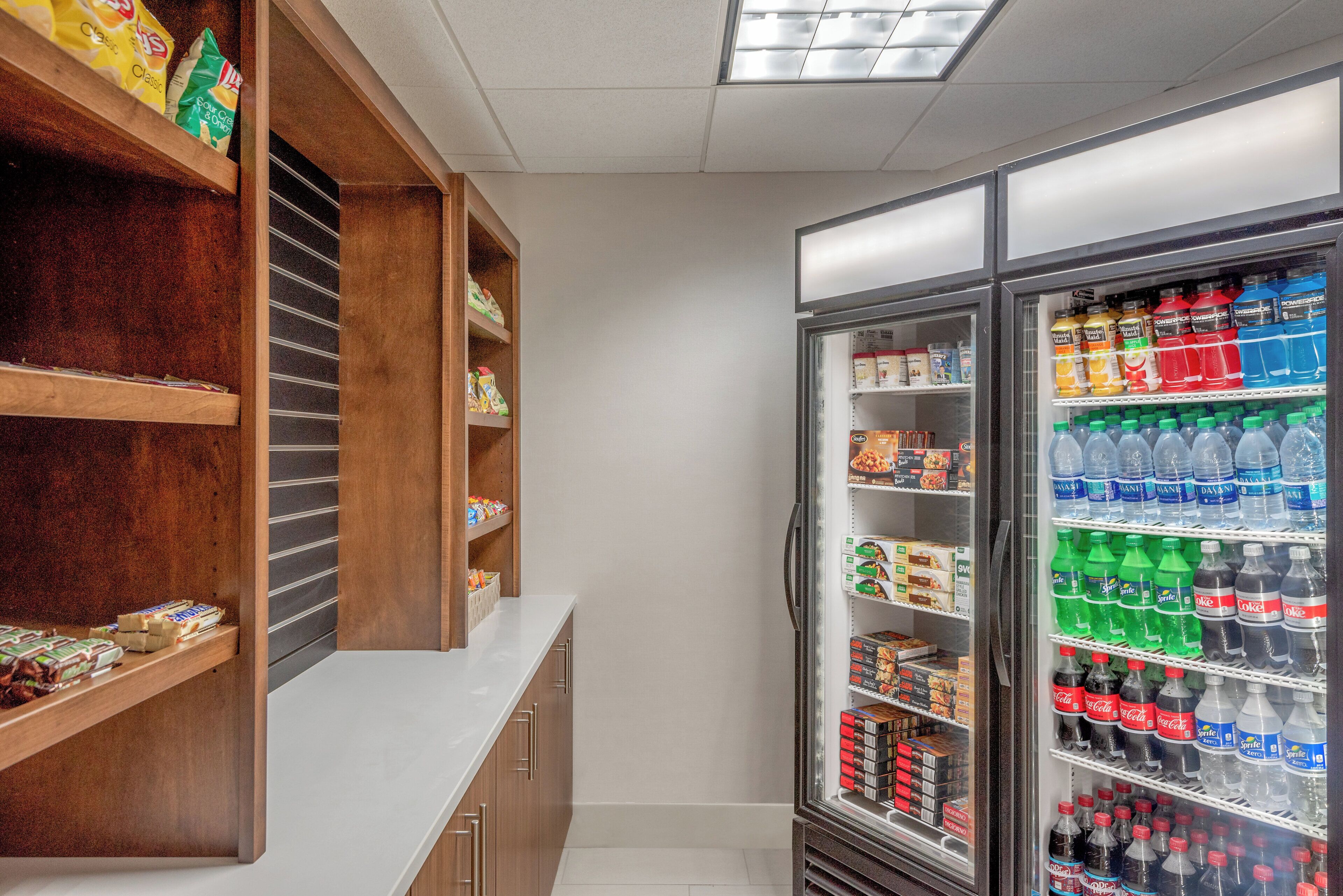 A kitchenette with a refrigerator stocked with beverages and snacks.