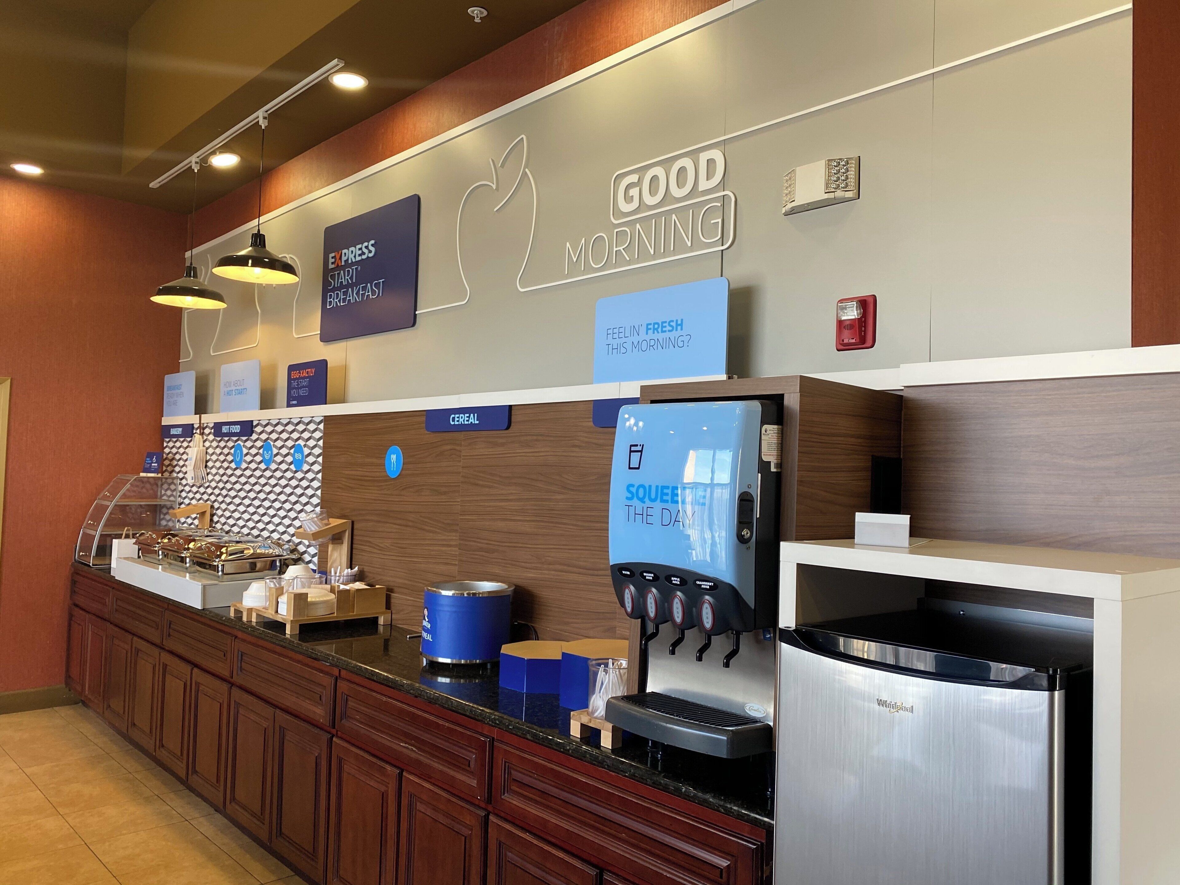 A breakfast area with a coffee machine, cereal dispenser, and a sign that says 'GOOD MORNING.'