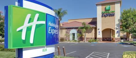 Une enseigne Holiday Inn Express offrant une vue dégagée sur l’entrée de l’établissement et le parking.