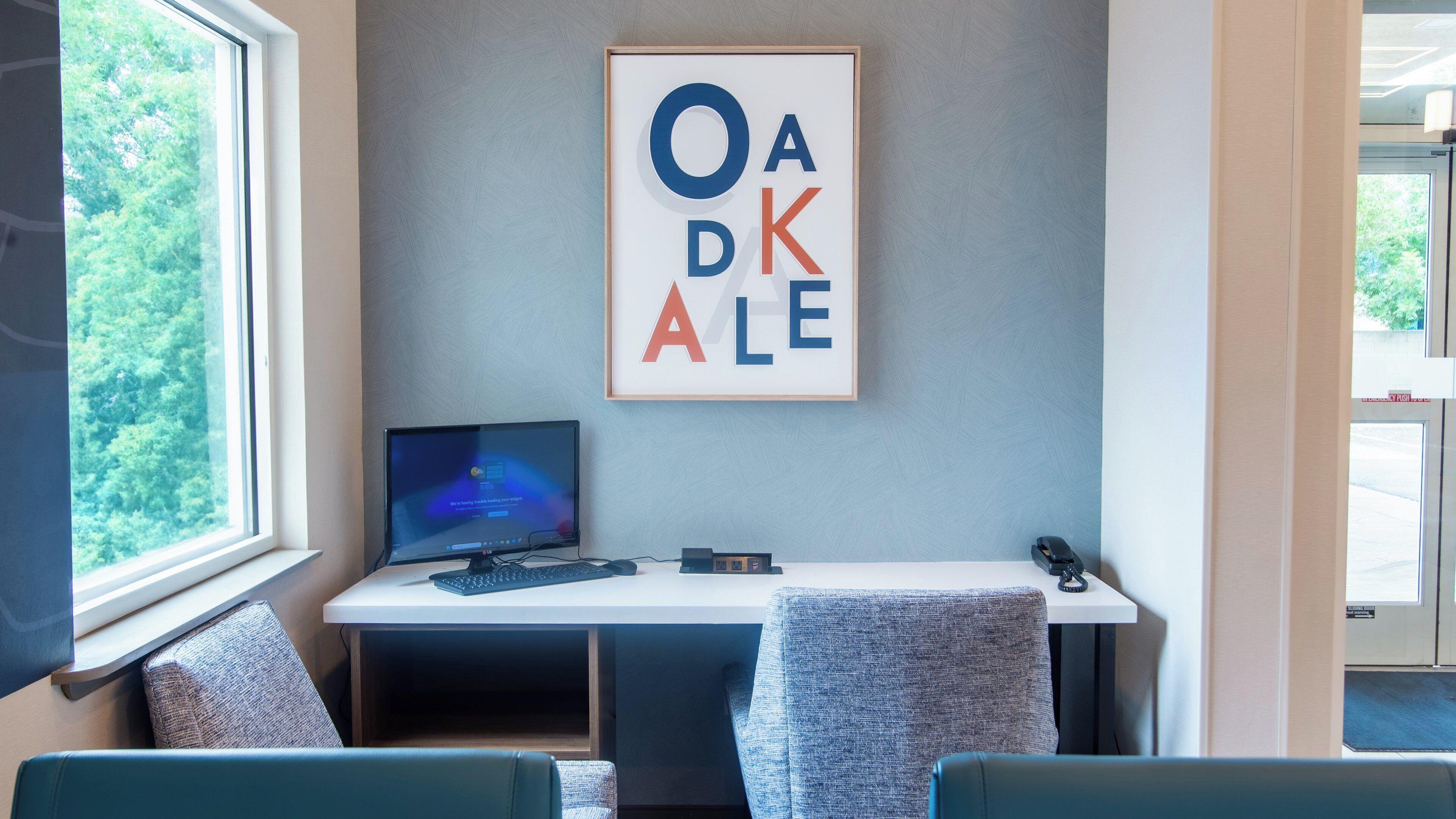 A modern office space with a desk, computer, and seating area.