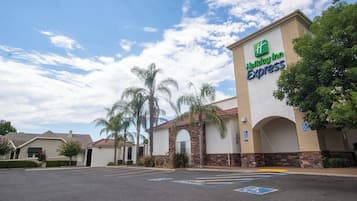 A Holiday Inn Express building with a parking lot and palm trees.