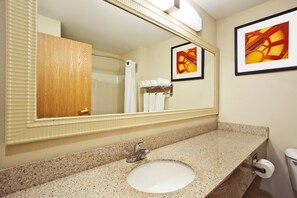 A bathroom with a granite countertop, a sink, a mirror, a towel rack, and a toilet. - Holiday Inn Express Hotel & Suites Columbus-Groveport by IHG (Groveport)