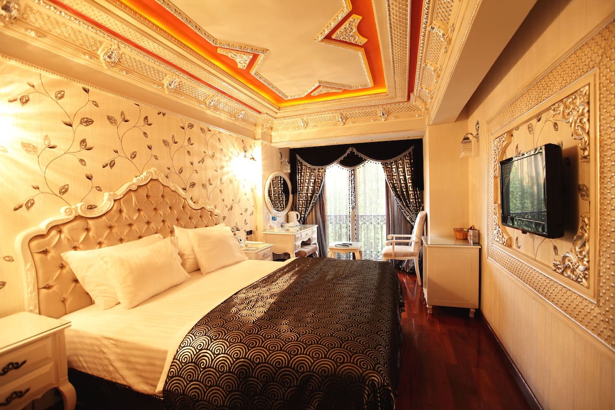 Une chambre d’hôtel luxueuse, dotée d’un grand lit, d’une télévision, d’un bureau et d’une chaise.