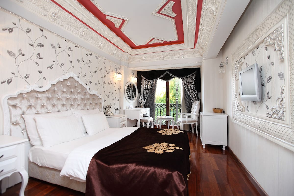 Une chambre avec un grand lit, une télévision, un bureau et une chaise.