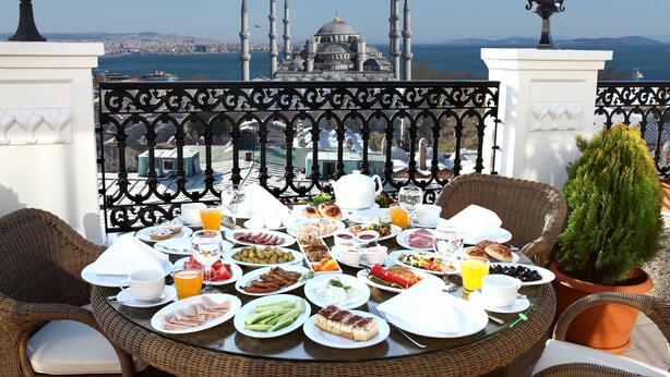 A table set for breakfast with a view of a mosque and sea. - Deluxe Golden Horn Sultanahmet Hotel (Istanbul)