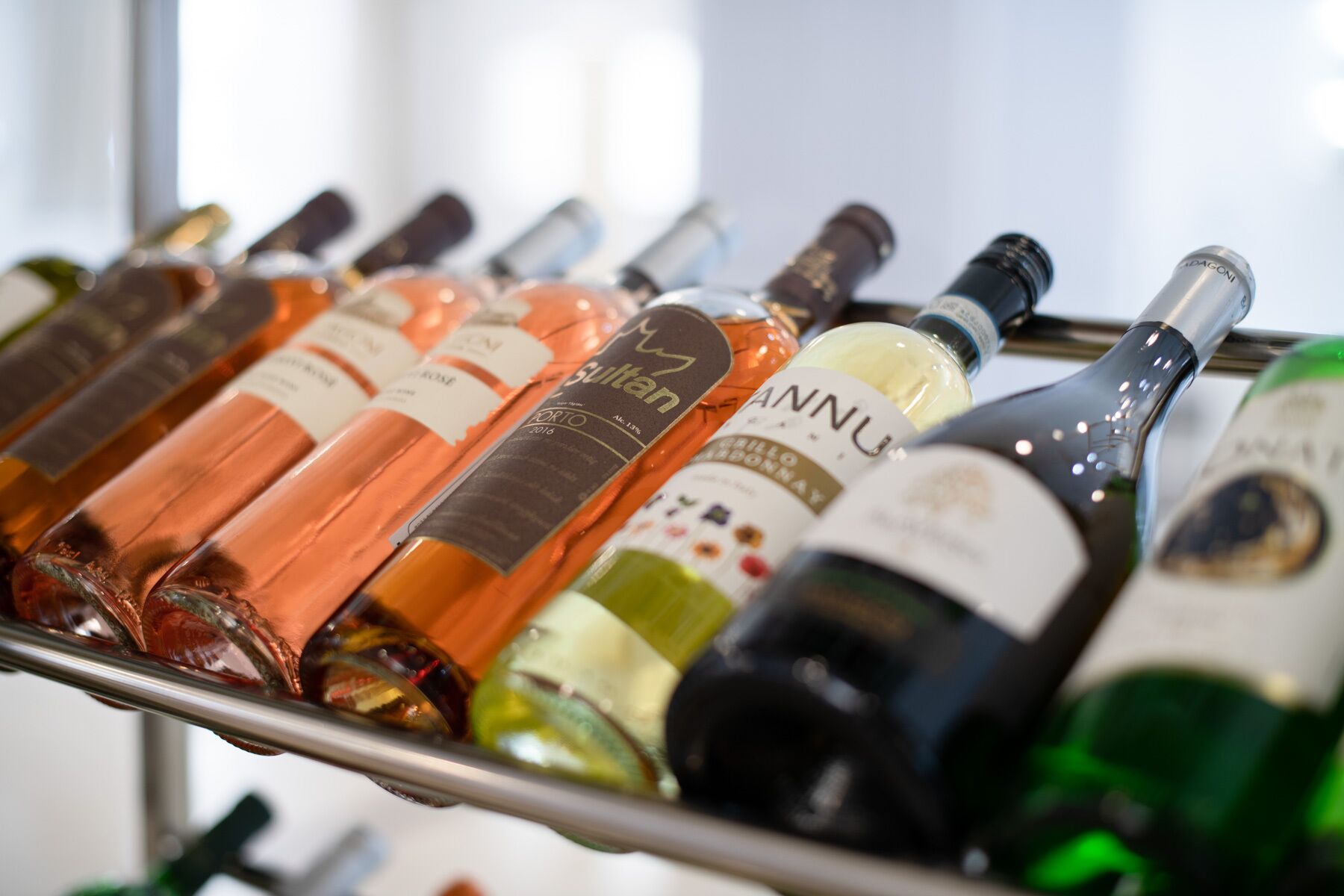 A rack of wine bottles with labels indicating different varieties and regions.