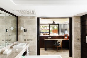 A modern bathroom with dual sinks, a large mirror, and a view of a pool and outdoor area.