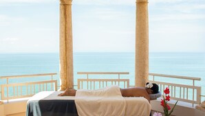 A room with a bed, a view of the sea, and a balcony with columns. - Rincon Beach Resort (Añasco)