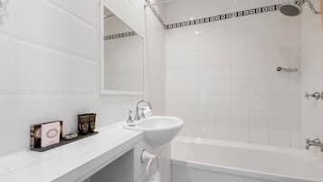 A modern bathroom with a white sink, a bathtub, and a shower.