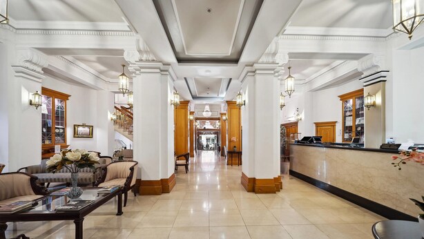 A hotel lobby with a reception desk, seating area, and a staircase leading to upper floors. - Castlereagh Boutique Hotel, an Ascend Collection Hotel (Sydney)
