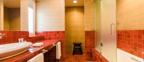 A modern bathroom with a large sink, mirror, and shower area.