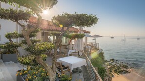 A seaside restaurant with outdoor seating, a terrace, and a view of the sea. - The Albatroz Hotel (Cascais)