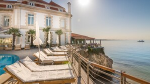 A seaside hotel with a pool, sun loungers, and a view of the sea. - The Albatroz Hotel (Cascais)