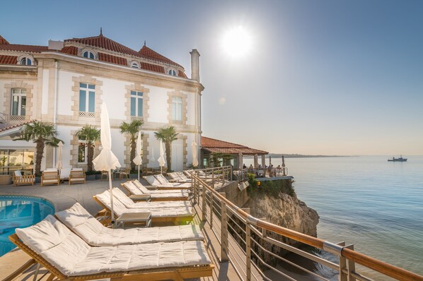 Piscine extérieure, parasols de plage, chaises longues