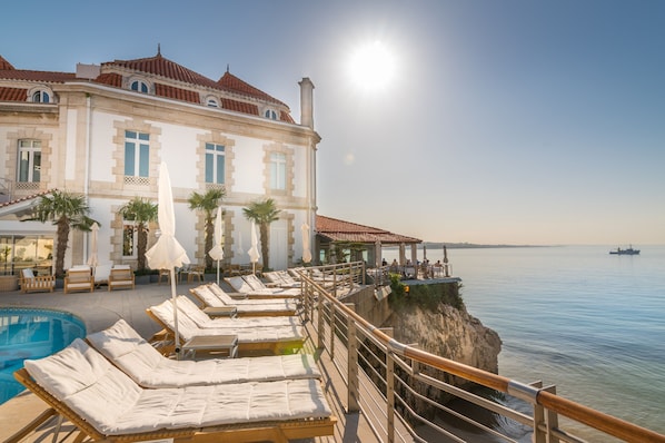 Piscine extérieure, parasols de plage, chaises longues