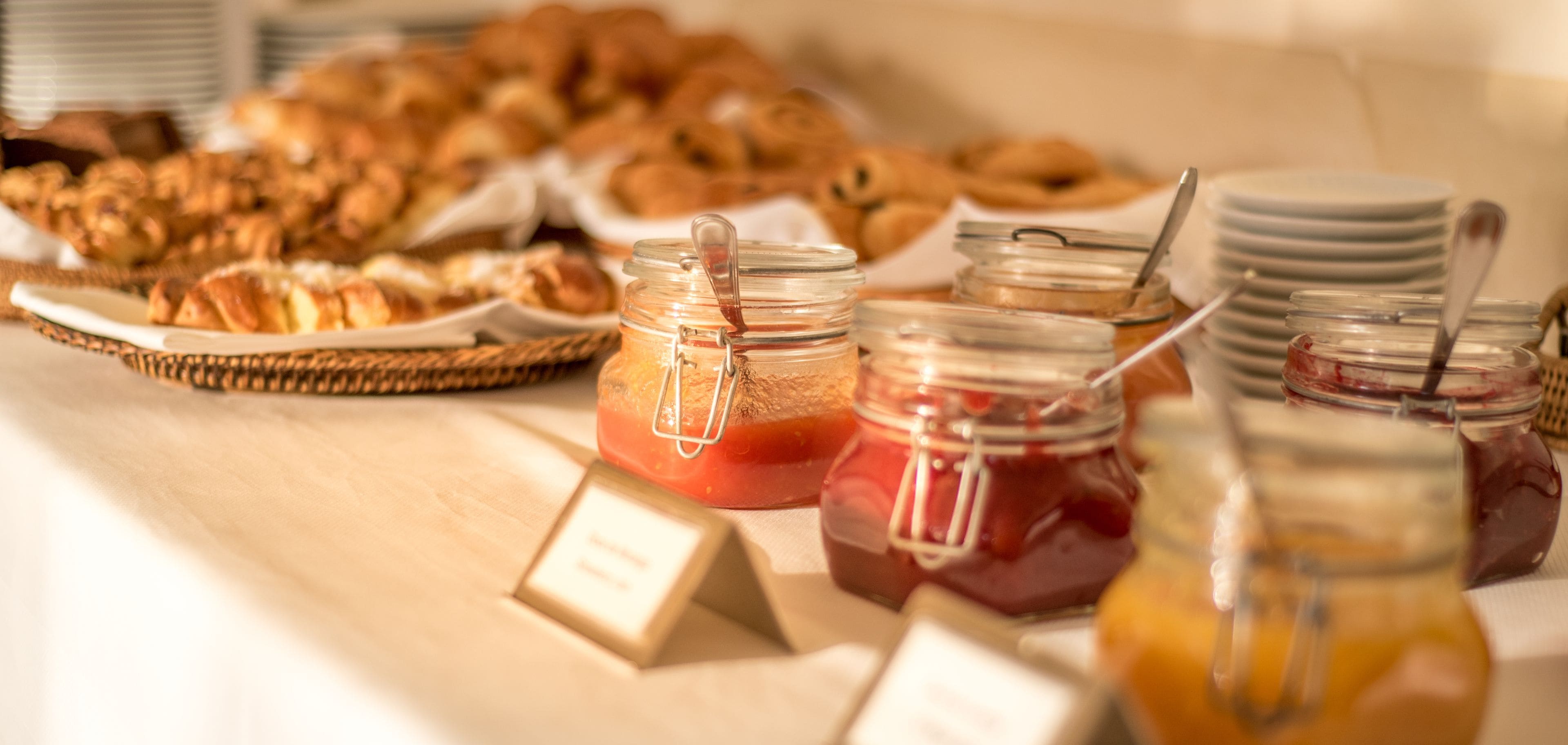 A breakfast buffet with various pastries and jams.