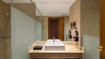 A modern bathroom with a large mirror, a sink, and a shower.