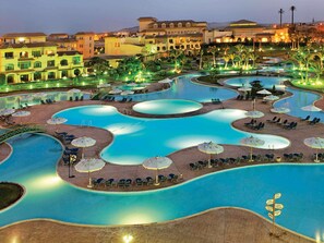 A resort with multiple swimming pools, sun loungers, and umbrellas.