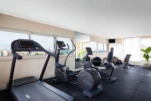 Ein modernes Fitnessstudio mit Laufbändern, Crosstrainern und Gewichtsgeräten.