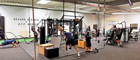 A gym with various exercise equipment and a high ceiling.
