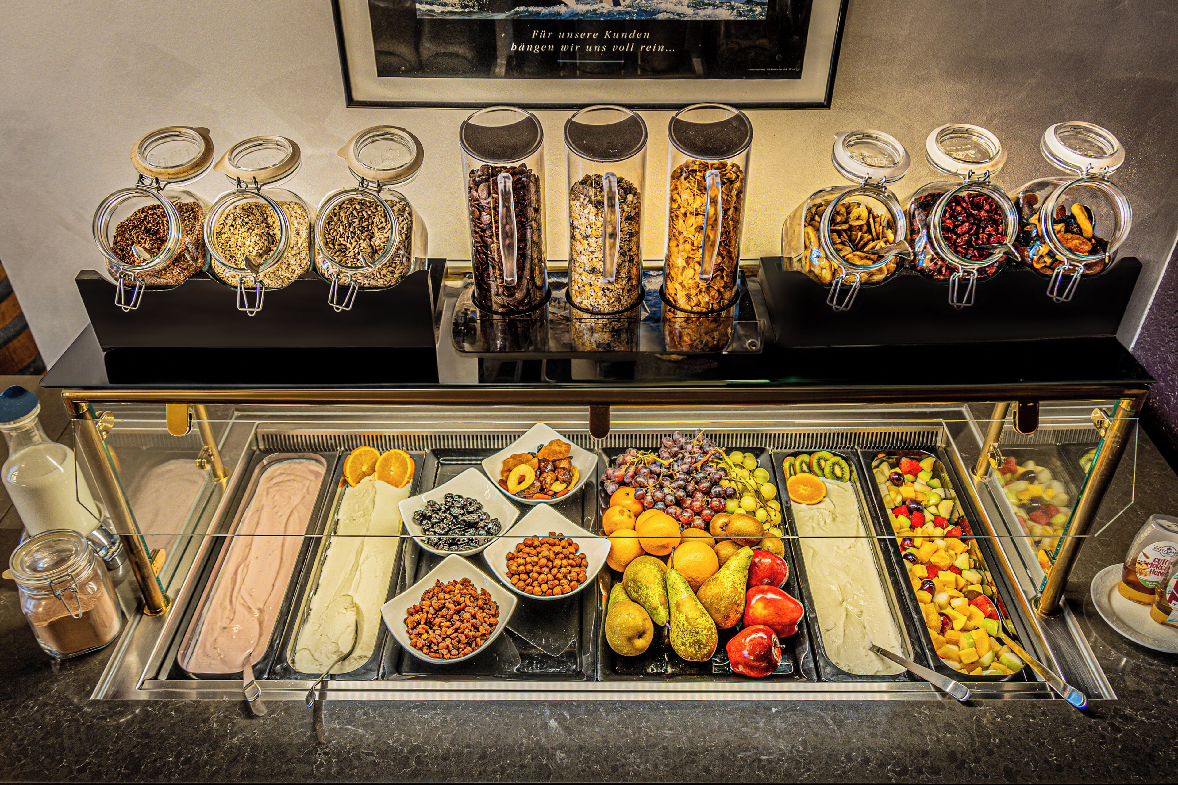 Ein reichhaltiges Buffet mit verschiedenen Speisen, darunter Obst, Gemüse und unterschiedliche Aufstriche.
